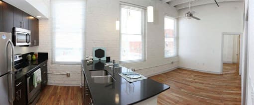 an empty kitchen with a black counter top