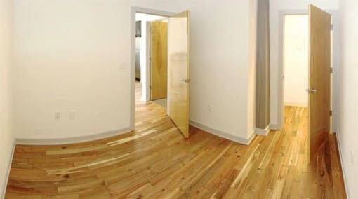 a empty room with wooden floors and a door