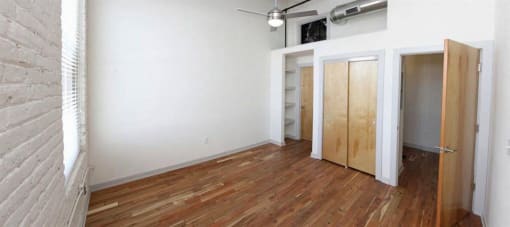 an empty room with a wooden floor and a closet