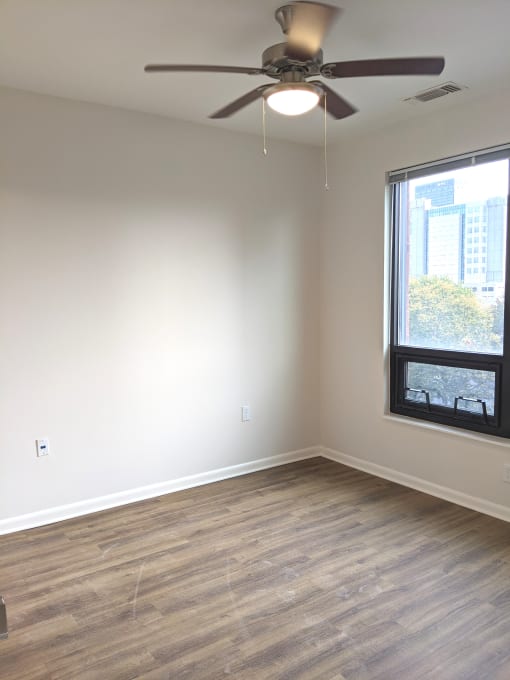 Apartment bedroom with ceiling fan, window, and hardwood floors, Beecher Terrace I, Louisville, KY