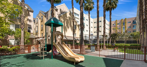 a playground with a slide in front of an apartment building