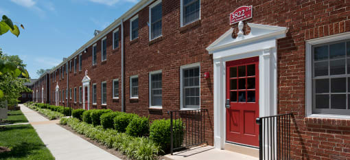 a brick apartment building with a red door at Clarendon Court