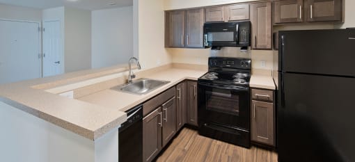 a model kitchen with black appliances at Clarendon Court Apartments