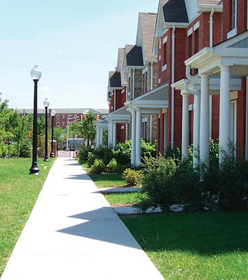 A long white pathway leads the eye through a grassy area and up a hill.