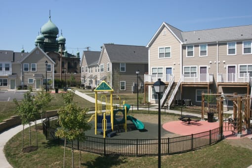 Apartment building exterior and playground area, Tremont Pointe Apartments