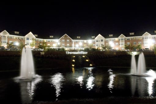 Apartment buildings and pond at night-Senior Living at University Place Apartments, Memphis, TN 38104