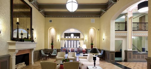 a lobby with couches and chairs and a fireplace at Valentine Apartments