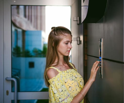 A women trying to open the apartment door with a controlled access system