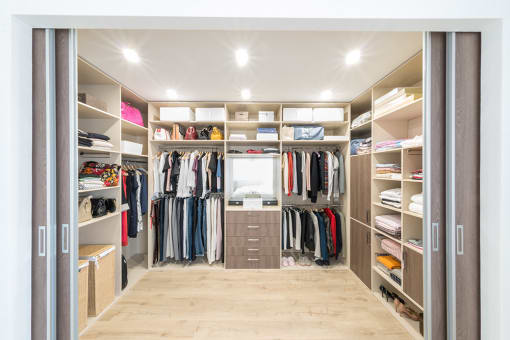Spacious walk-in closet with with shelves and center isle