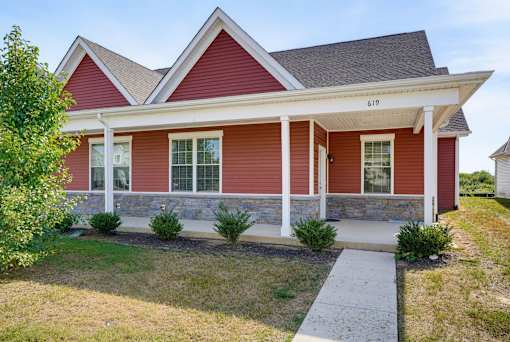 A red house with white trim and a porch.