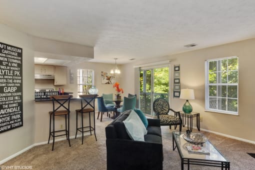 the living room and kitchen of an apartment with a couch and a table at Brookstone Village, Cincinnati
