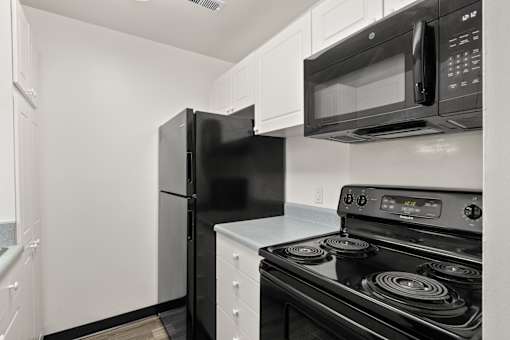 Kitchen with white cabinetry and black appliances at Creve Coeur, Creve Coeur, MO