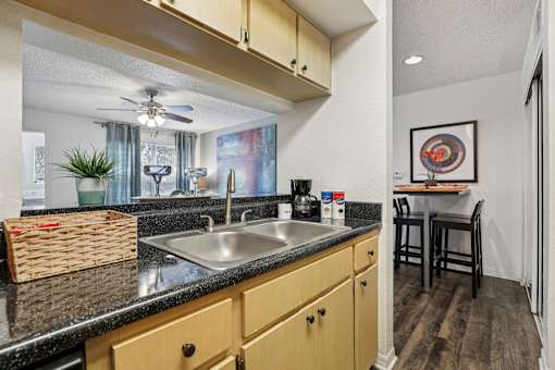 A kitchen with a black countertop and wooden cabinets. at University Park Apartments, Florida