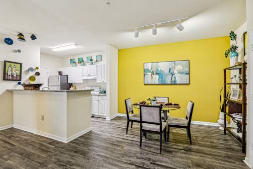 Open kitchen and dining area with yellow accent wall at The Arbor Walk Apartments, Tampa, FL 33617