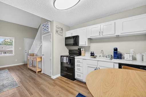 A kitchen with white cabinets and a black oven.at Lofts of Wilmington, Wilmington, NC, 28405