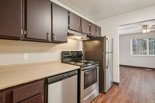A kitchen with dark brown cabinets and stainless steel appliances.at Aspen Townhomes, Colorado Springs, CO