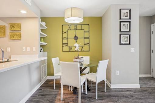A kitchen with a table and chairs in front of a green wall.