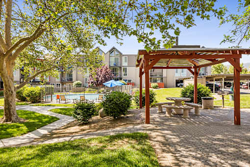 A park area with a picnic table and a tree.