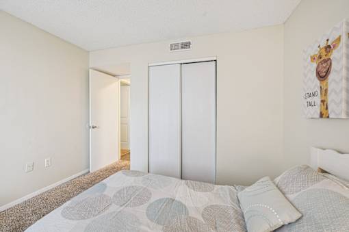 A bedroom with a bed and a giraffe poster on the wall. at Sarasota South Apartments, Bradenton, 34207