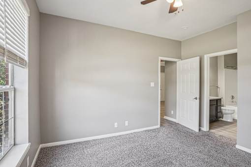 A room with a ceiling fan and a window with blinds at Bridford Lake Apartments, North Carolina, 27407