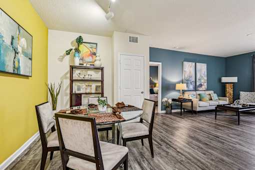 Open concept living and dining room with colorful accent walls at The Arbor Walk Apartments, Tampa, 33617