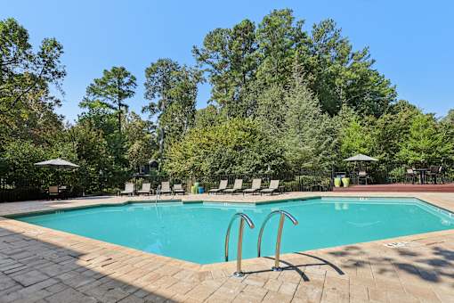 A swimming pool surrounded by trees and lounge chairs. at Canopy Glen, Georgia, 30093