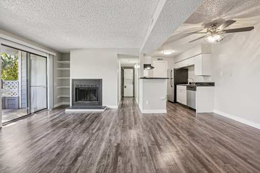 A spacious living room with wood flooring and a fireplace. at Windmill Apartments, Colorado, 80916