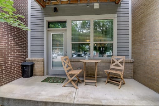 Apartment unit patio with two chairs and a table