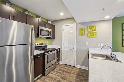 A kitchen with a stainless steel refrigerator, oven, and microwave.