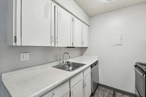 A kitchen with white cabinets and a granite countertop at Spyglass Creek, Denver, 80224