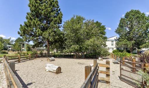 a dog park with trees and a wooden fence at Spyglass Creek, Denver, 80224