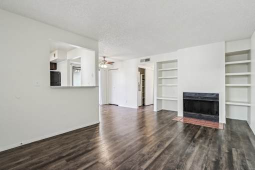 A living room with a fireplace and wood flooring at Del Coronado Apartment , Mesa, Arizona