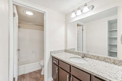 A bathroom with a sink, mirror, and toilet. at Cliffs at Canyon Ridge, Utah, 84401