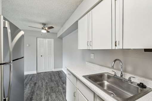 A kitchen with a stainless steel refrigerator, sink, and ceiling fan at Spyglass Creek, Denver, 80224