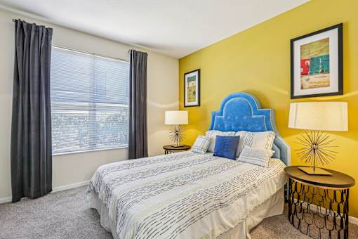 Bedroom with vibrant yellow accent wall and upholstered headboard at The Arbor Walk Apartments, Florida, 33617