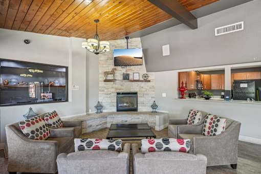 A living room with a stone fireplace and a television mounted on the wall. at University Village Apartments, Colorado