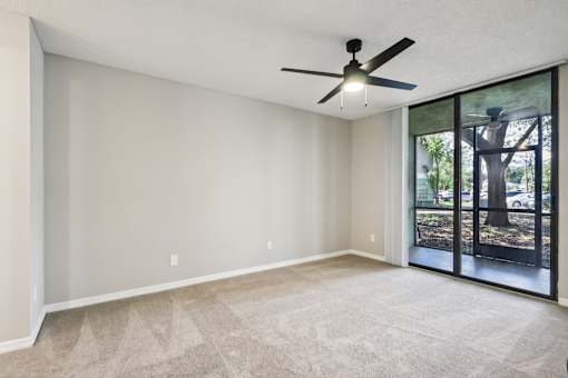 A room with a ceiling fan and sliding glass doors. at Lakeside Glen Apartments, Florida