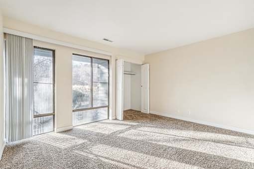 A sunny day with a room having a carpet and a sliding glass door. at Cliffs at Canyon Ridge, Utah, 84401
