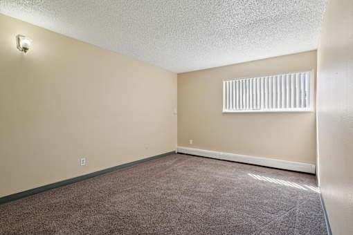 A room with a carpeted floor and a window with blinds. at Broadmoor Springs, Colorado Springs