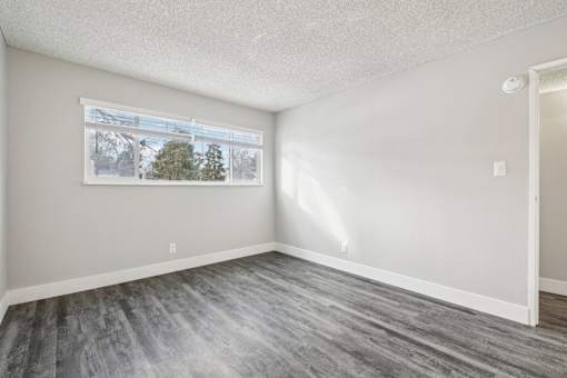 A room with a grey floor and a window showing a tree outside at Spyglass Creek, Denver, 80224