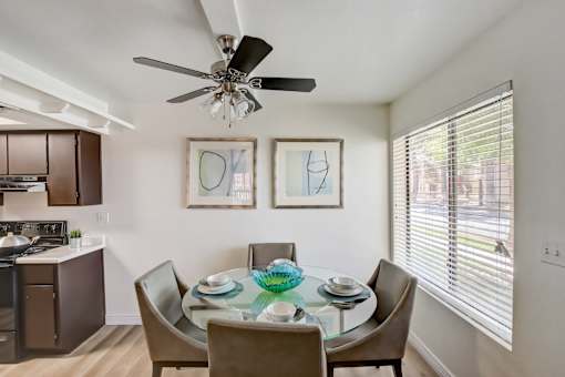 a dining area with a glass table and chairs and a ceiling fan at Glen at Mesa Apartments, AZ 85201