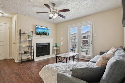 A living room with a grey couch and a fireplace.