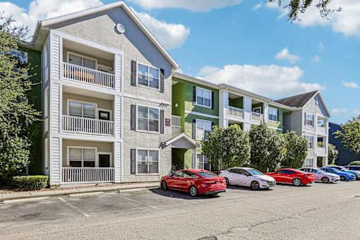 Exterior view of multi story apartment buildings with parking at The Arbor Walk Apartments, Tampa, FL