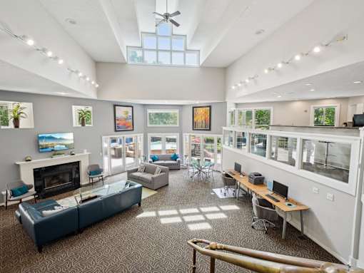 A spacious room with a fireplace, couches, and a ceiling fan. at University Ridge Apartments, North Carolina, 27707
