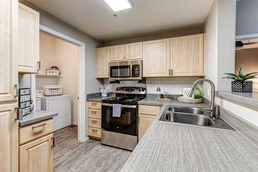 A kitchen with a stove, oven, and sink at Sweetwater At Metro North Apartments, Phoenix