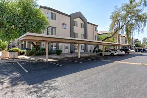 A parking lot in front of a building with a white car parked at Sweetwater At Metro North Apartments, Arizona