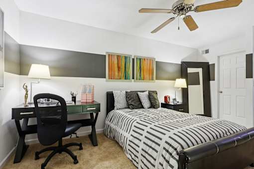 Bedroom with a bed, desk, and chair at Whisper Lake Apartments, Winter Park, FL, 32792
