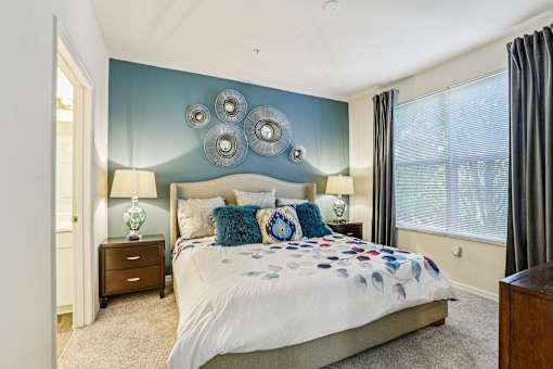 Bedroom with teal accent wall and decorative mirrors at The Arbor Walk Apartments, Tampa, Florida