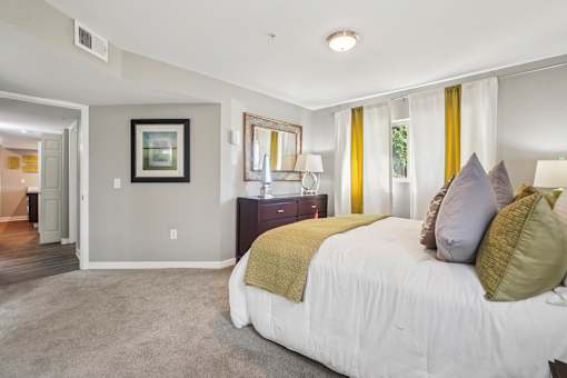 A bedroom with a large bed and a painting on the wall.