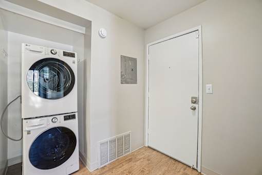 A white door is in a room with a washer and dryer.